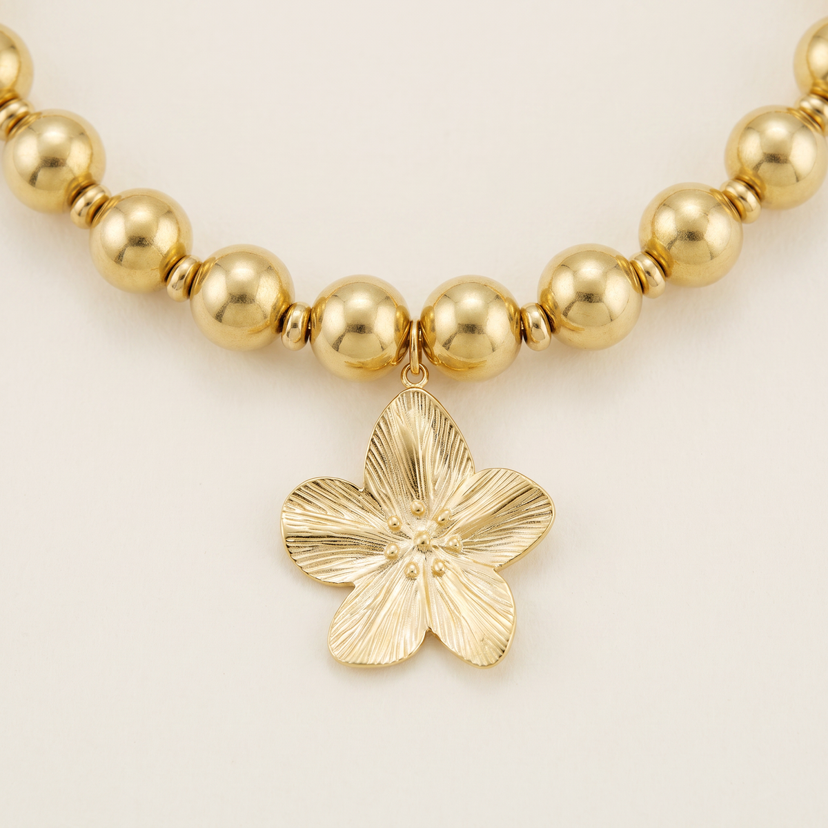 Collier fleur sur chaîne à boules, détail du motif, doré