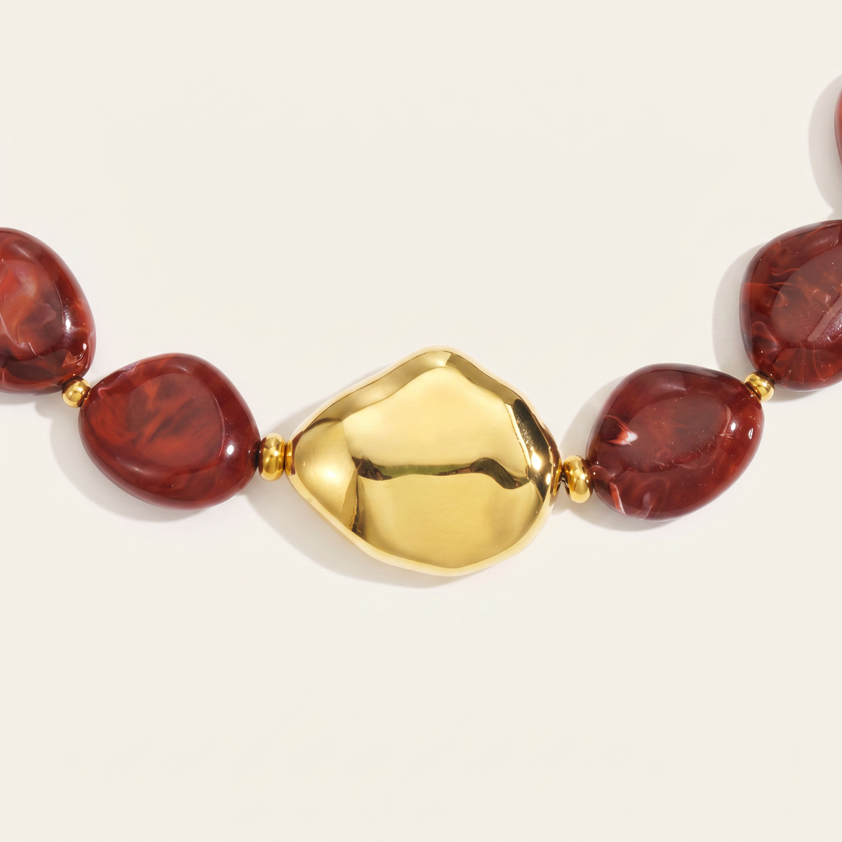 Collier de perles effet marbré de forme plate, détail du motif