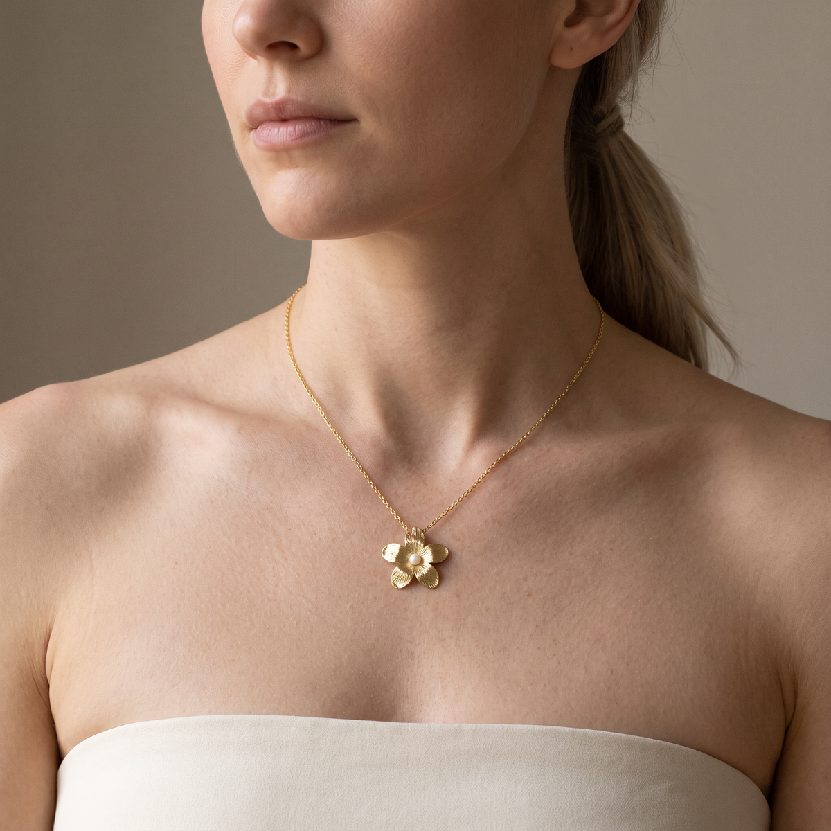 Collier fleur doré à finition texturée en perles, porté mi-corps