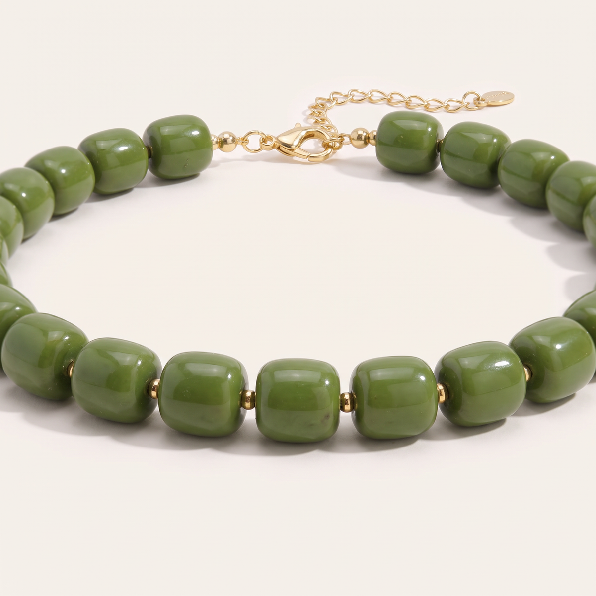 Collier de perles doré, détail du motif, kaki