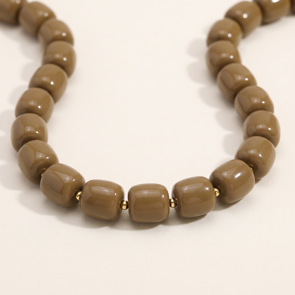 Collier de perles doré, détail du motif, marron