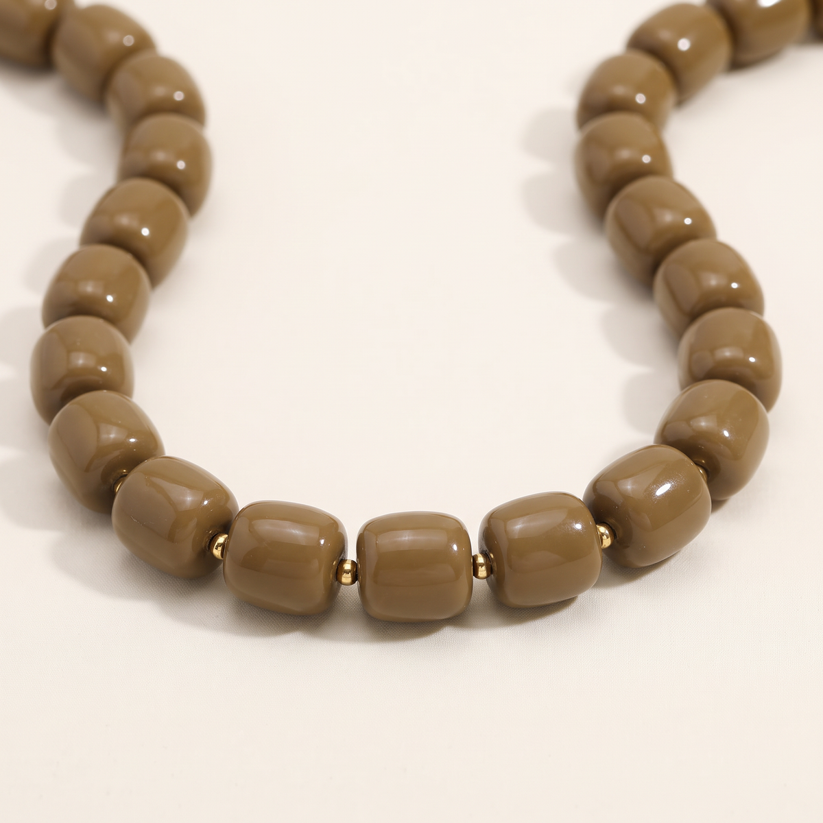 Collier de perles doré, détail du motif, marron