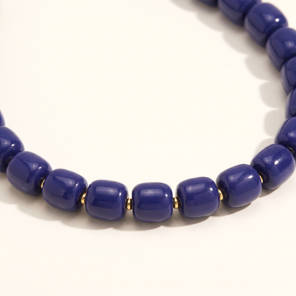 Collier de perles doré, détail du motif, bleu marine