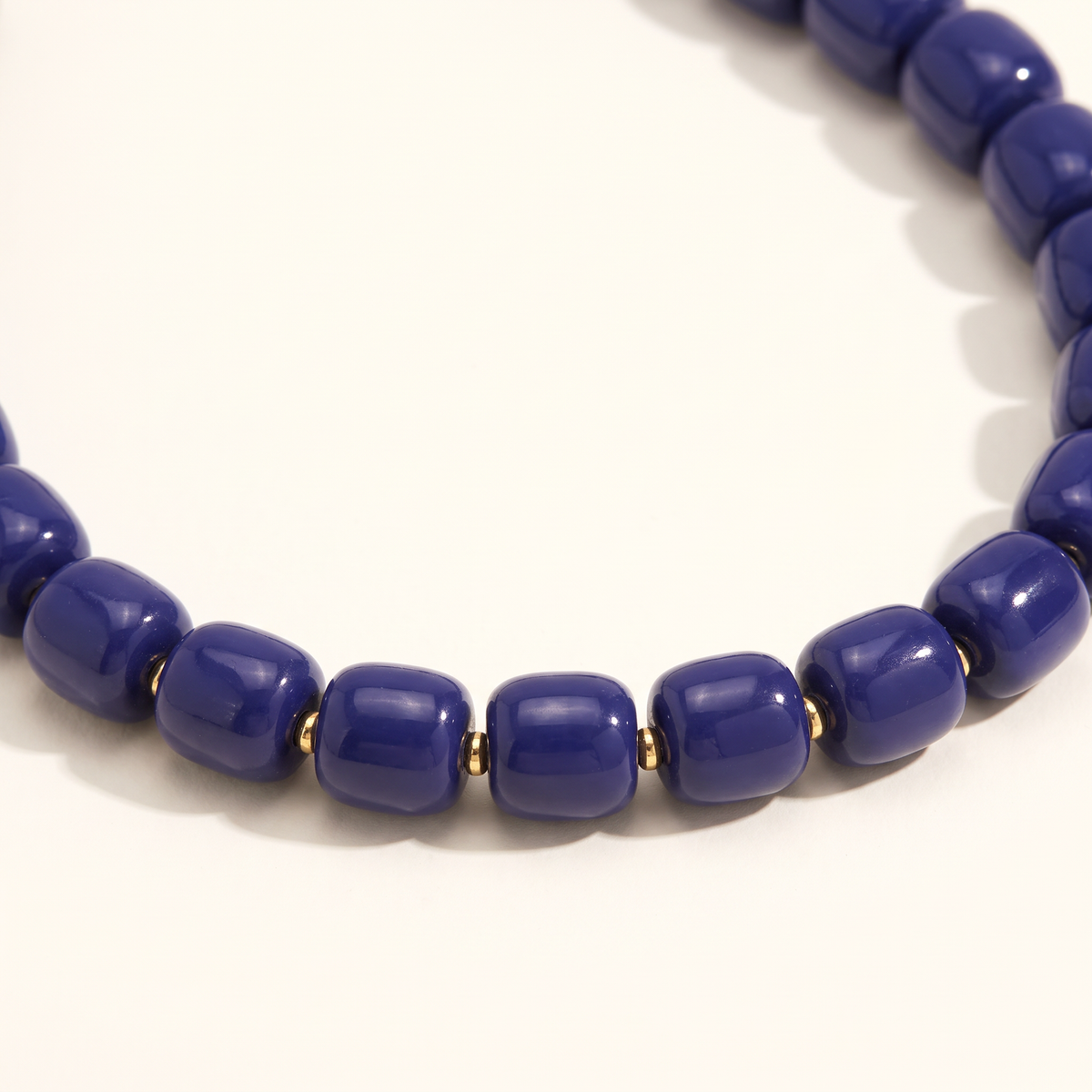Collier de perles doré, détail du motif, bleu marine