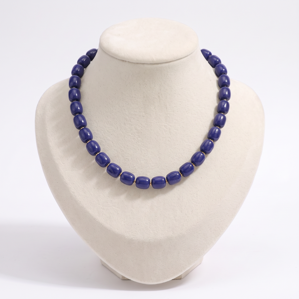 Collier de perles doré, vue de face, bleu marine