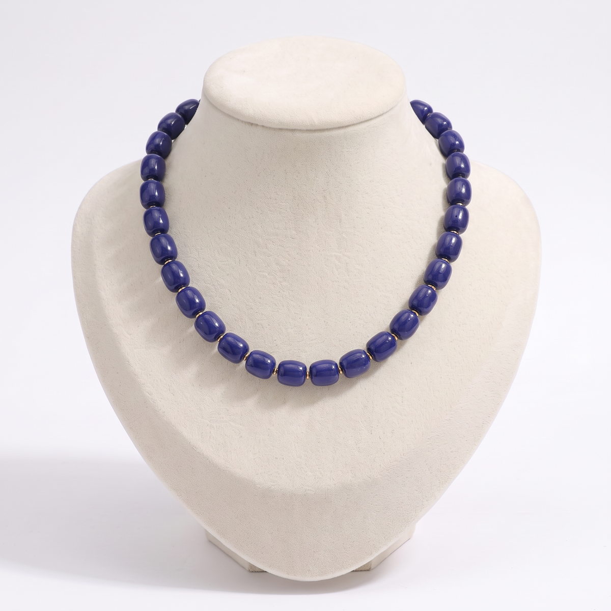 Collier de perles doré, vue de face, bleu marine