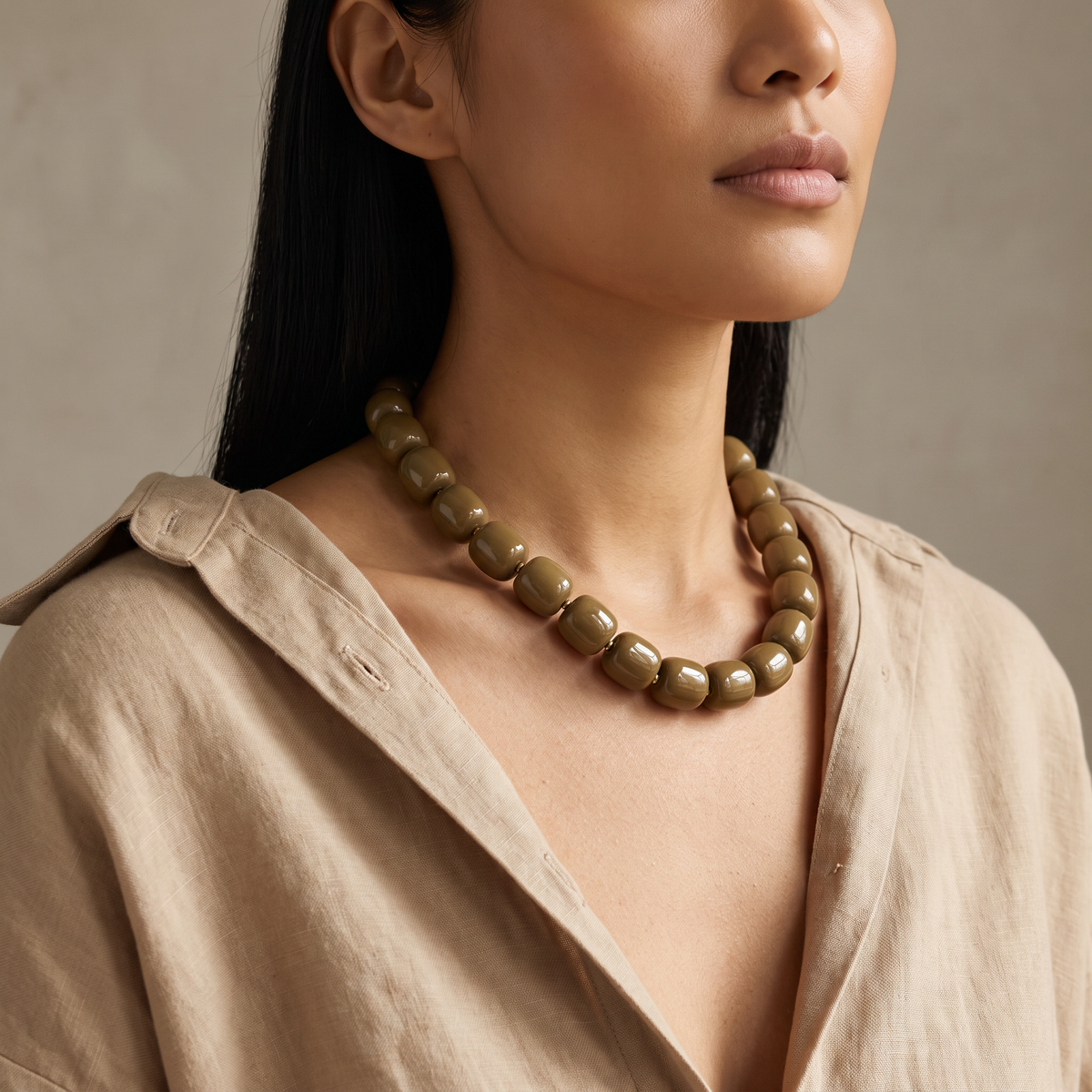 Collier de perles doré, porté mi-corps, marron