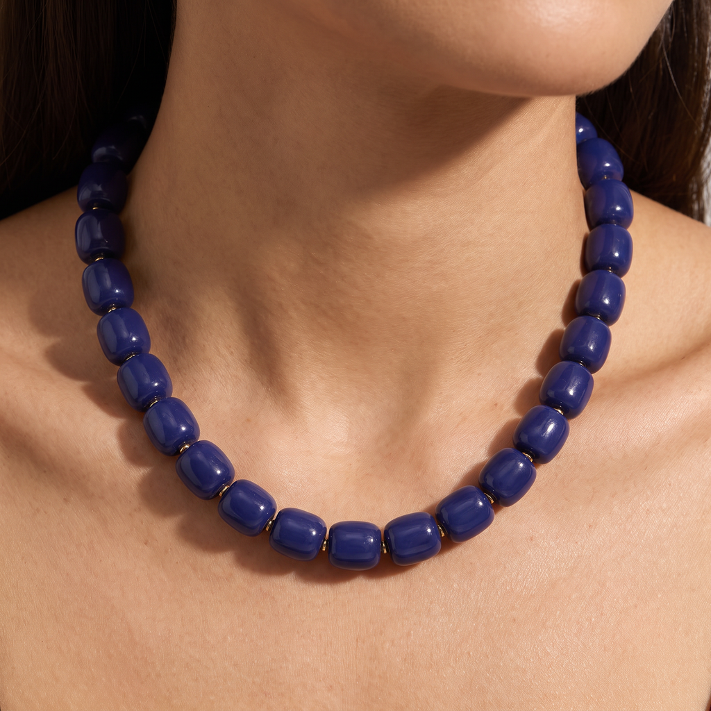 Collier de perles doré, porté, bleu marine