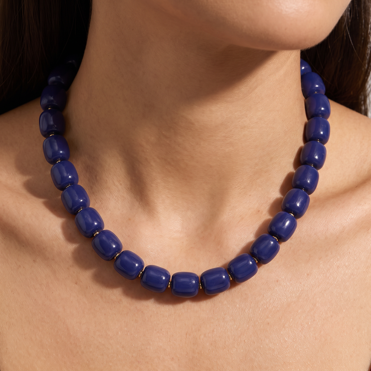 Collier de perles doré, porté, bleu marine