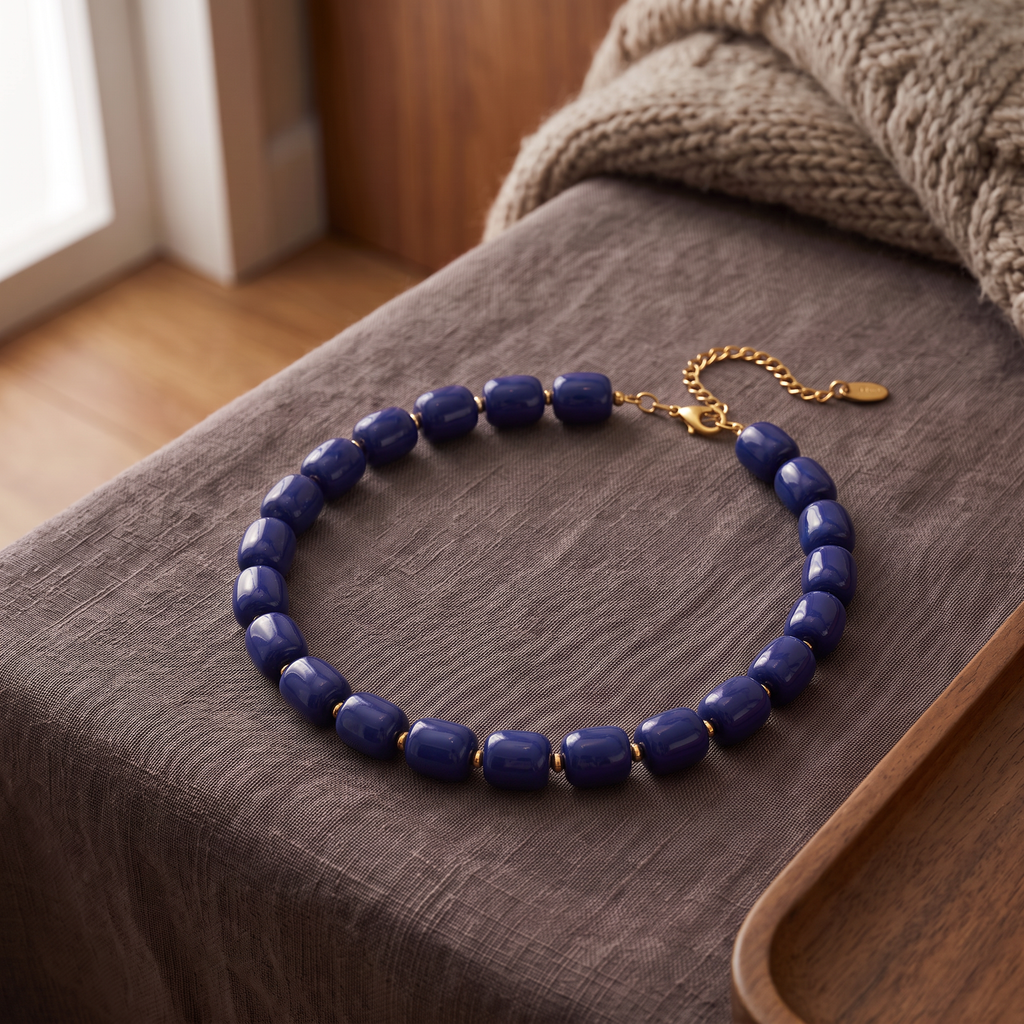 Collier de perles doré, porté en tenue, bleu marine