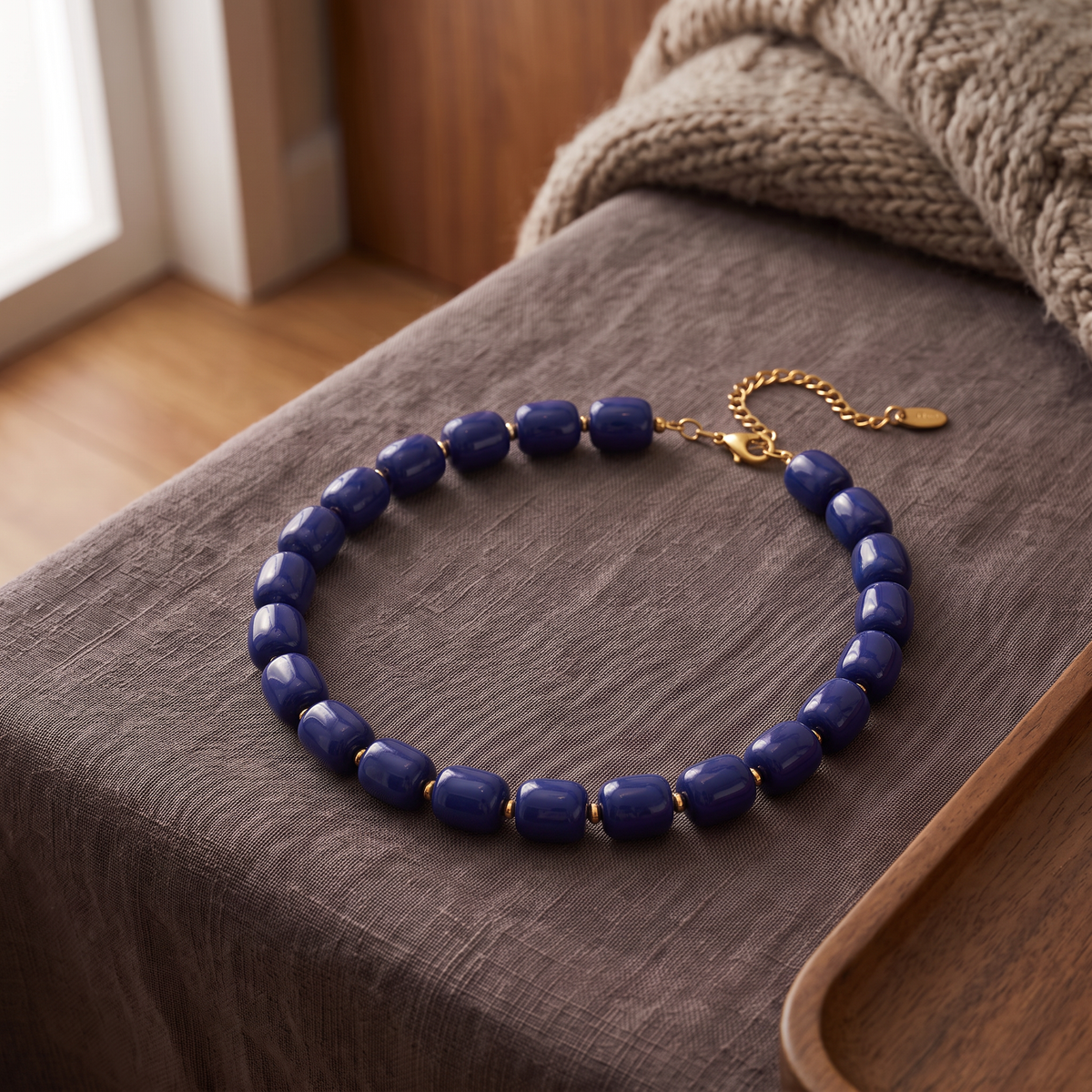 Collier de perles doré, porté en tenue, bleu marine