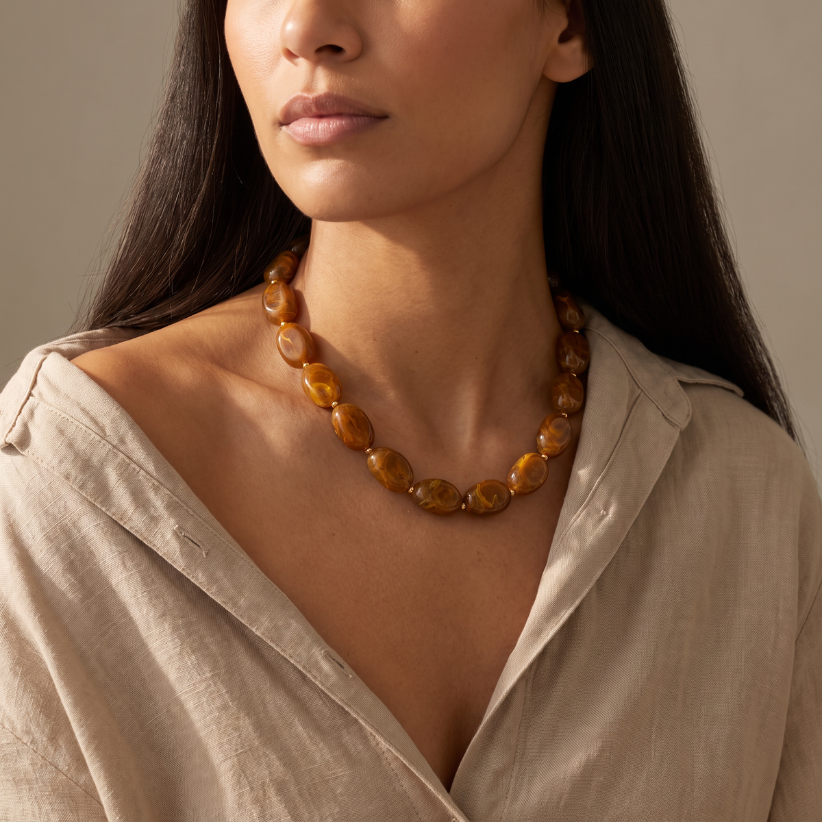 Collier de perles en couleurs, porté mi-corps, marron