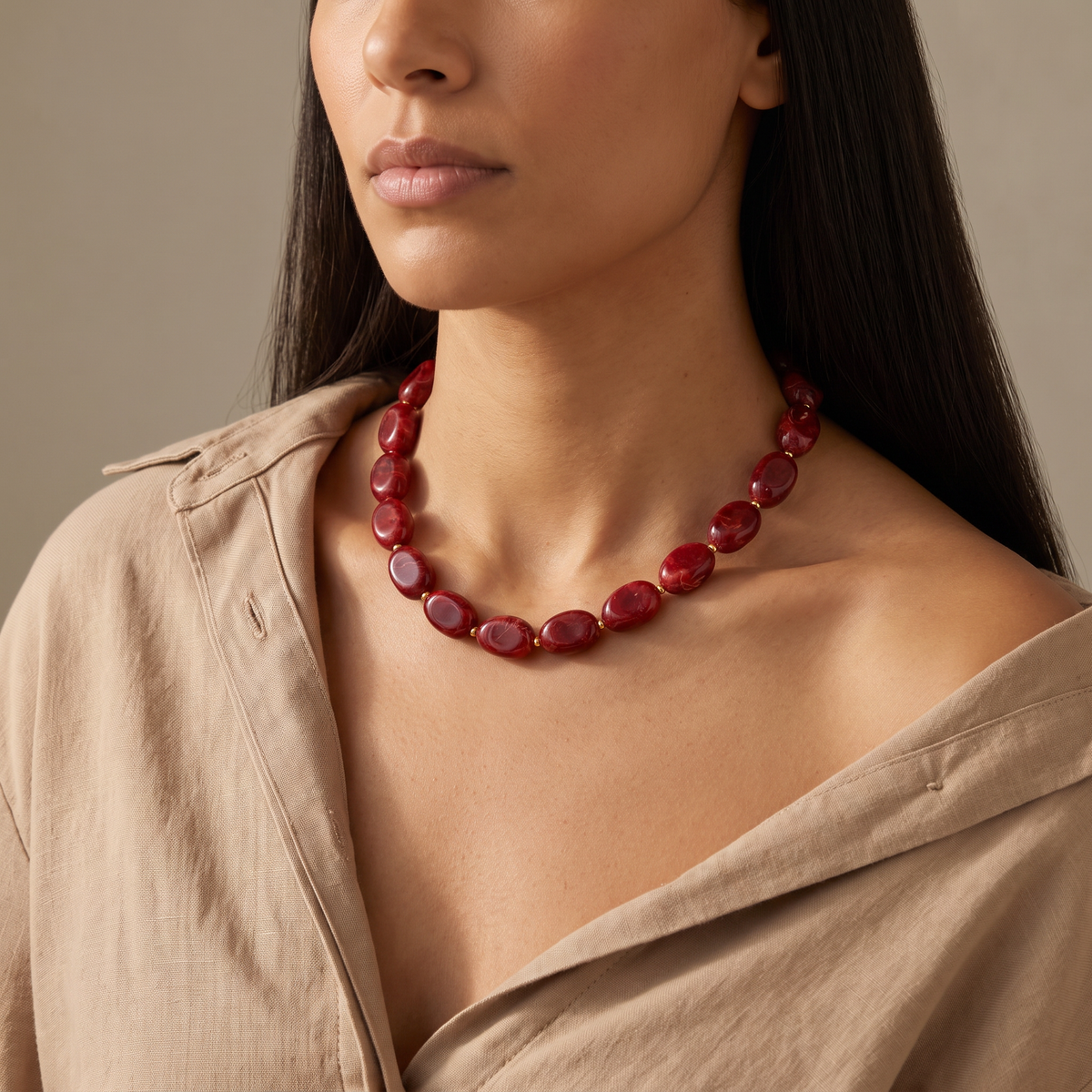 Collier de perles en couleurs, porté mi-corps, bordeaux