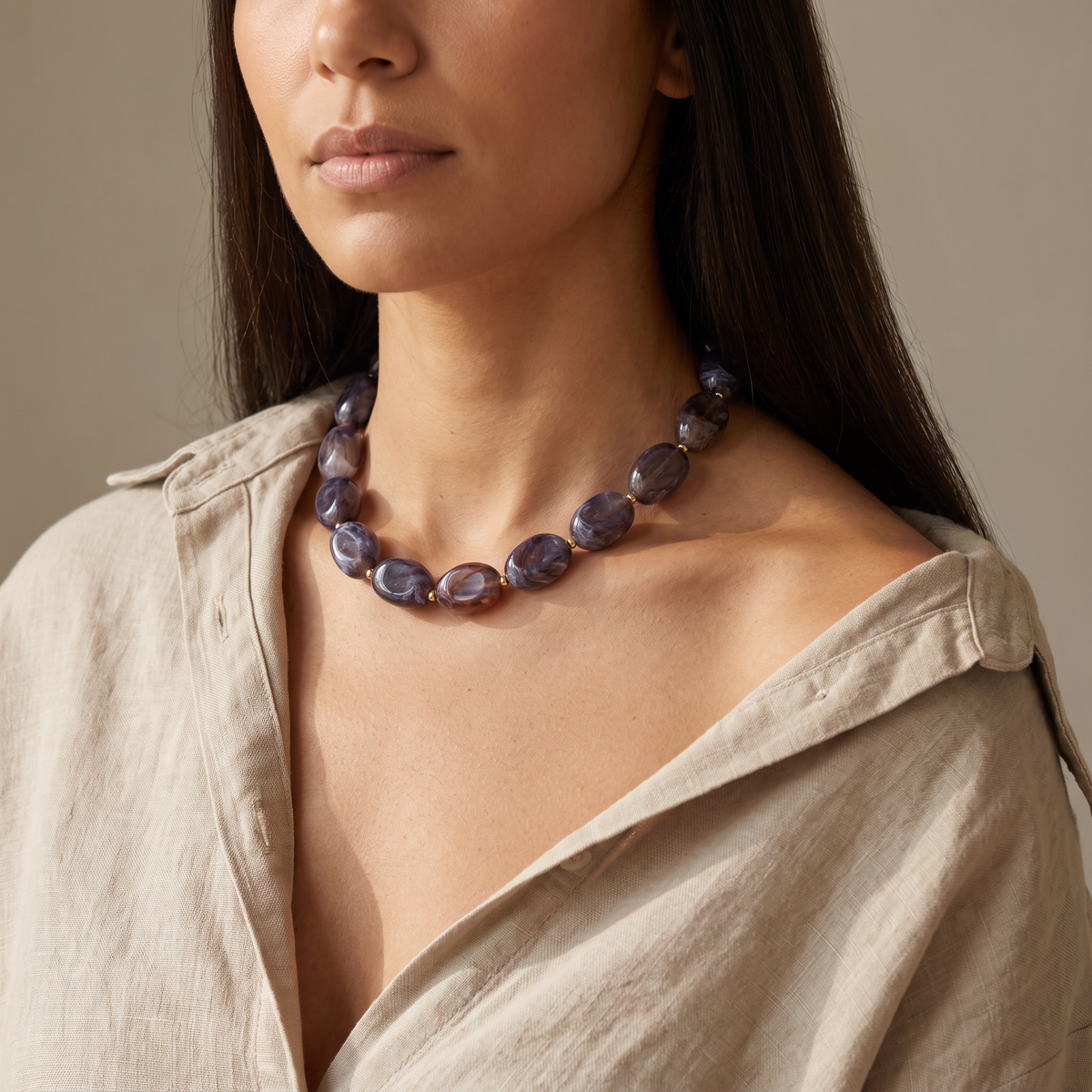 Collier de perles en couleurs, porté mi-corps, gris