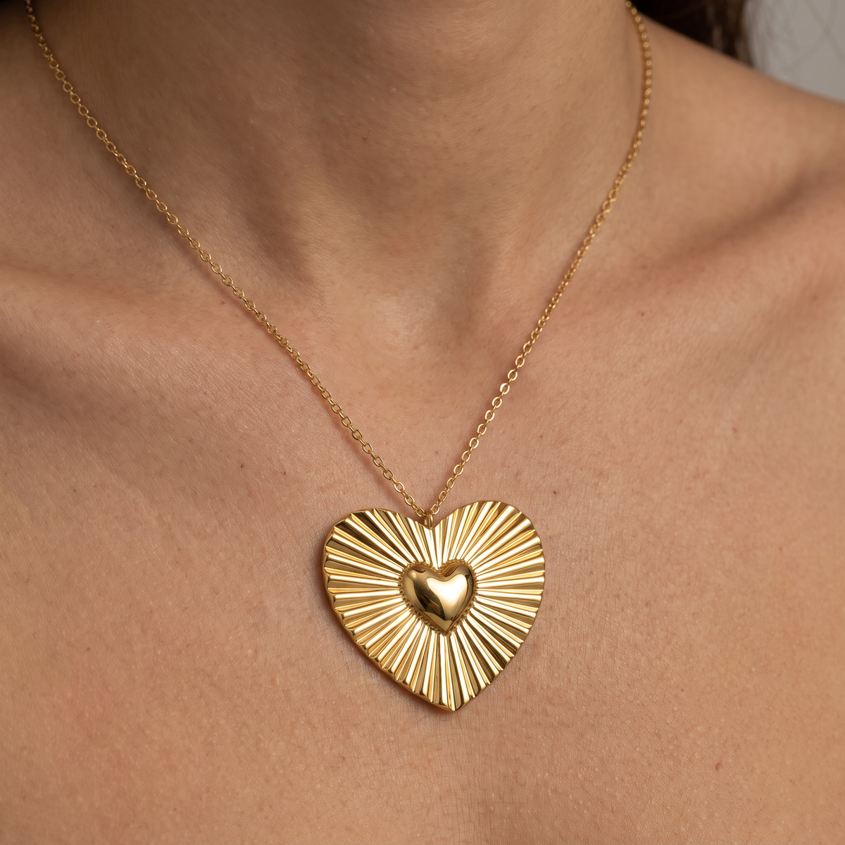 Collier cœur doré rayonnant, porté