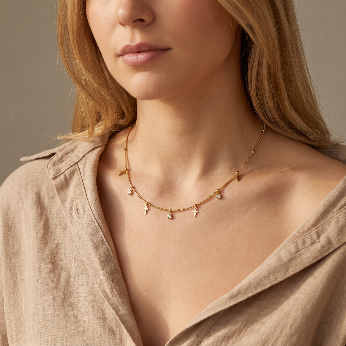 Collier croix doré à strass sur chaîne, porté mi-corps