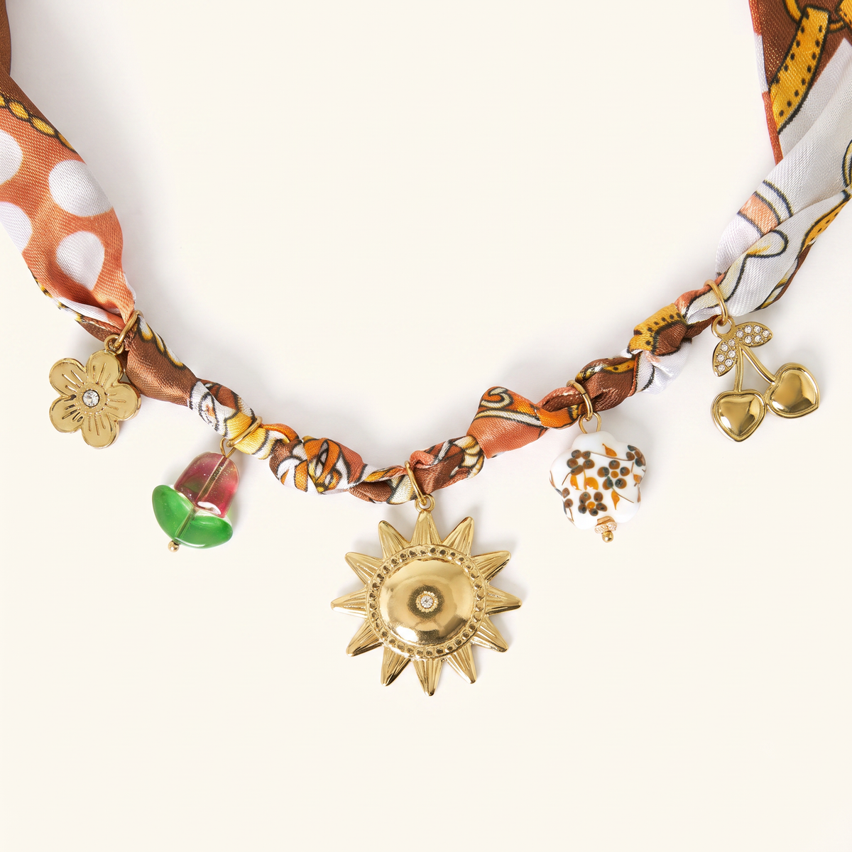 Collier doré à breloques imprimé, détail du motif