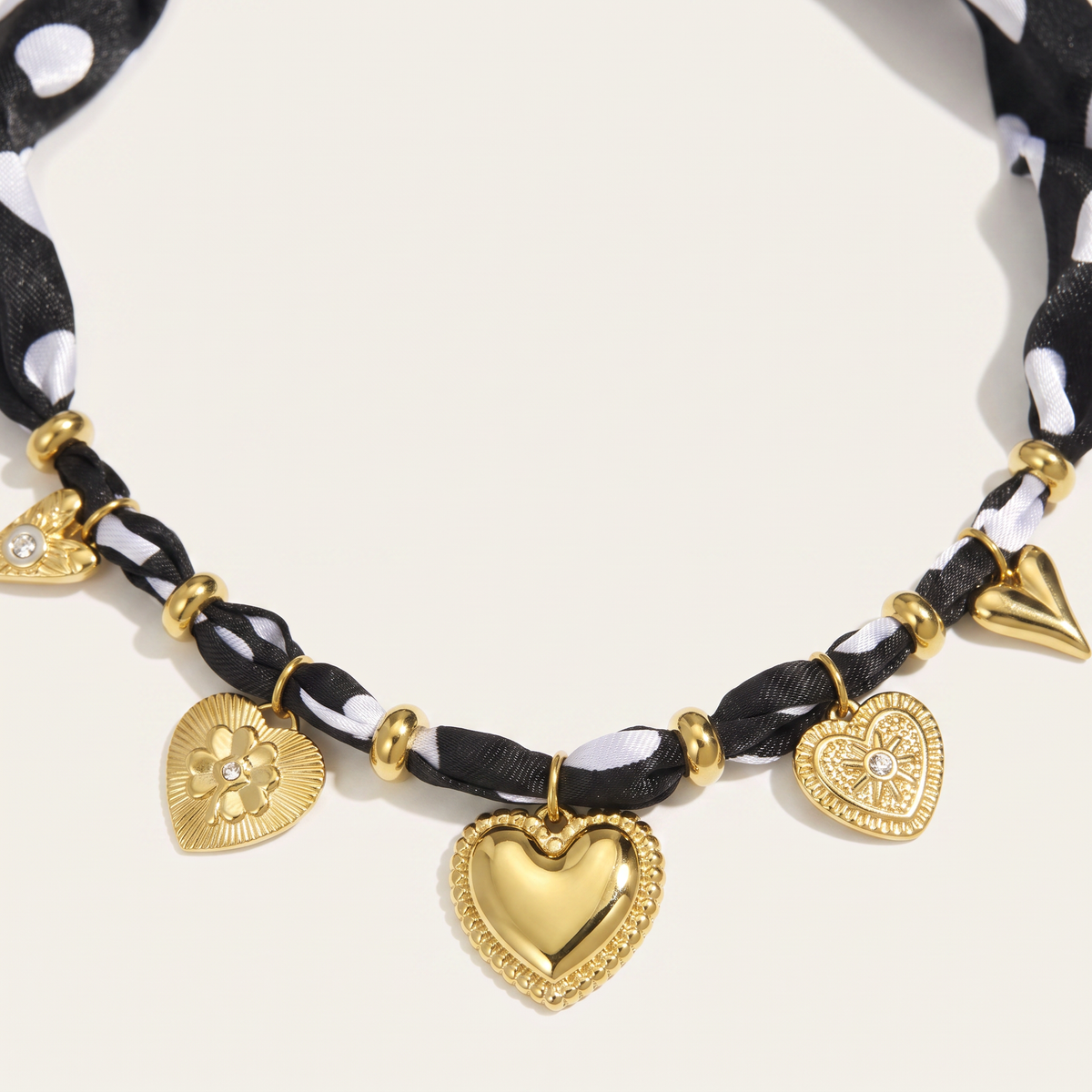 Collier cœur doré à pois sur cordon tressé, détail du motif