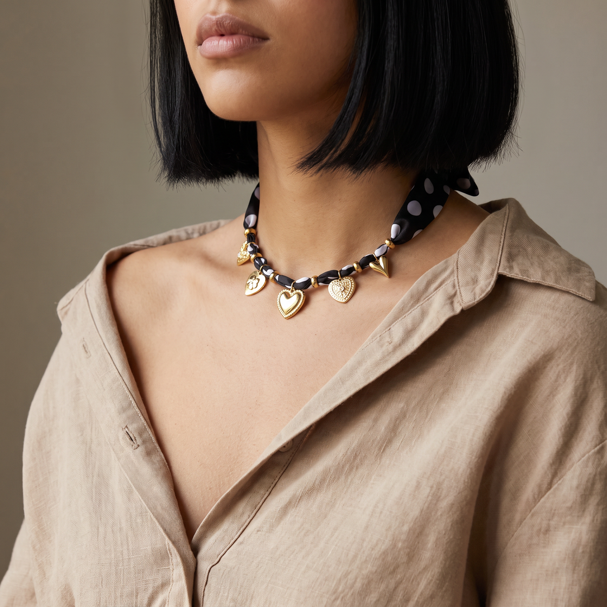 Collier cœur doré à pois sur cordon tressé, porté mi-corps
