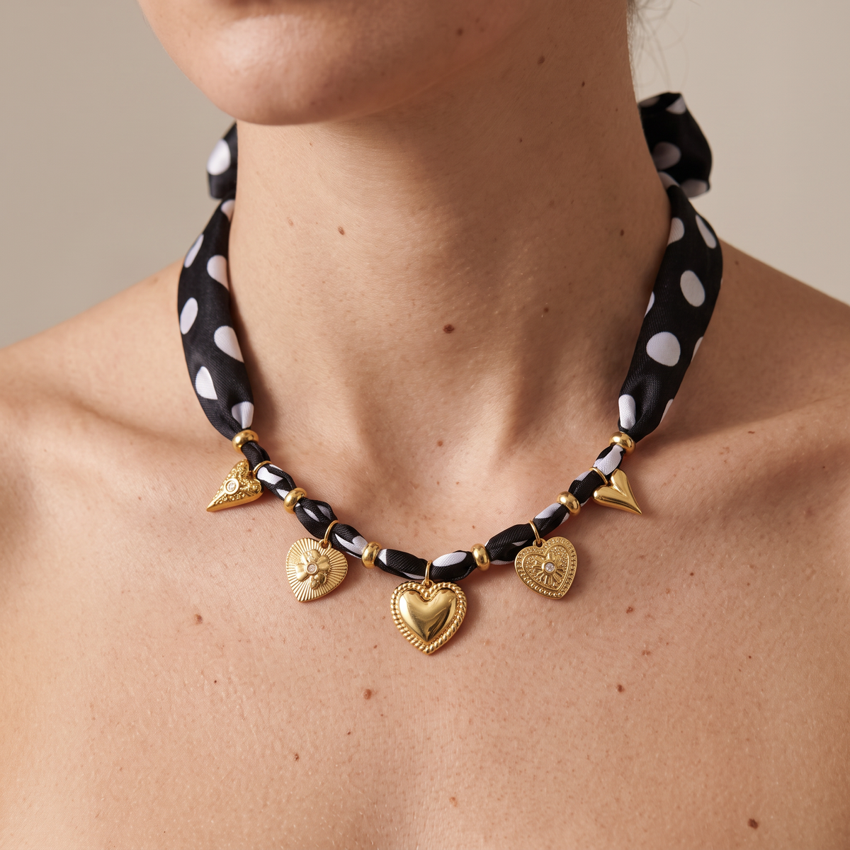 Collier cœur doré à pois sur cordon tressé, porté