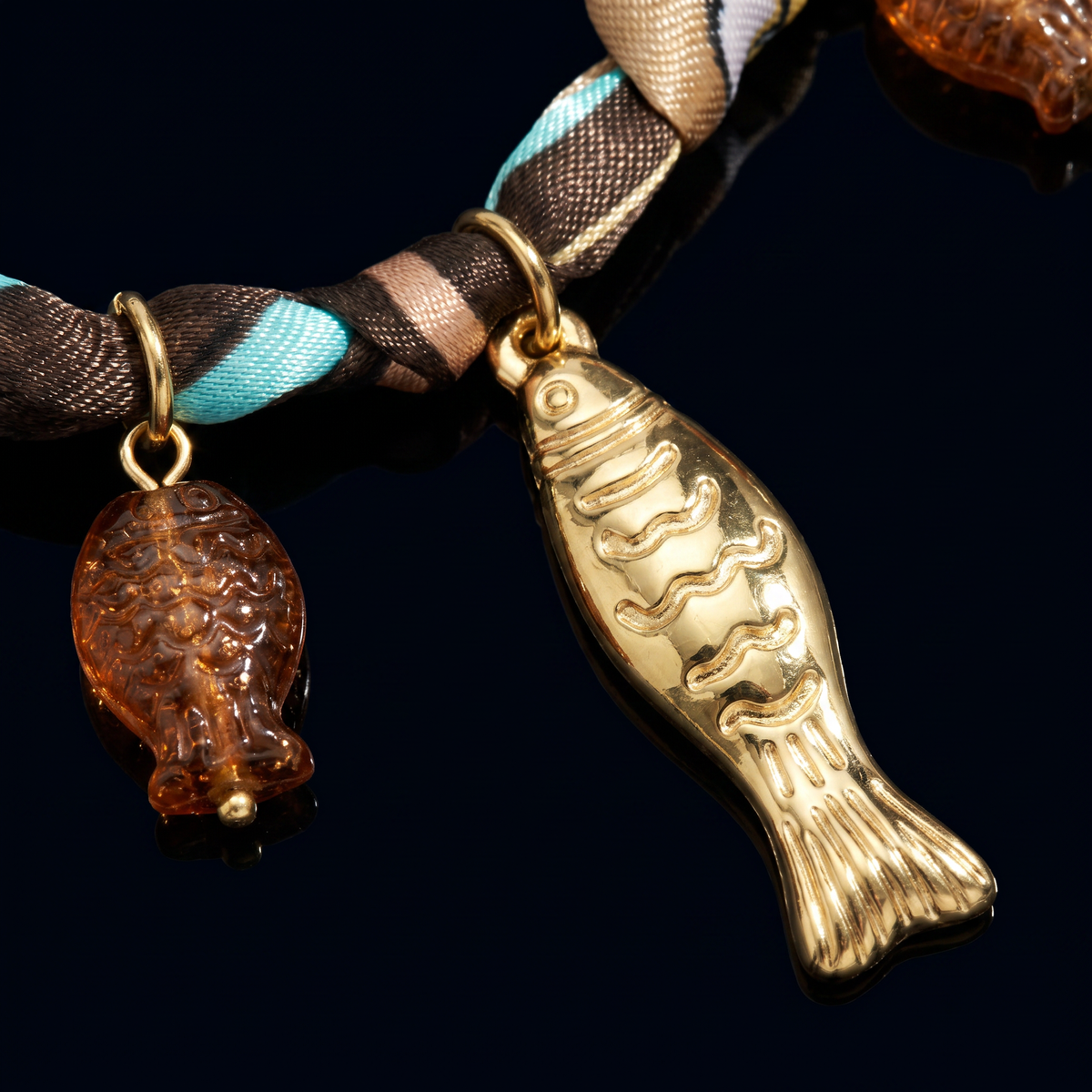 Collier poisson doré sur cordon foulard, motif en gros plan