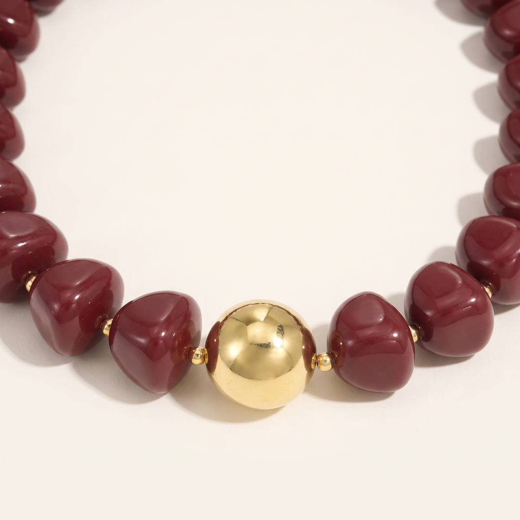 Collier de perles doré à sphères, détail du motif, bordeaux