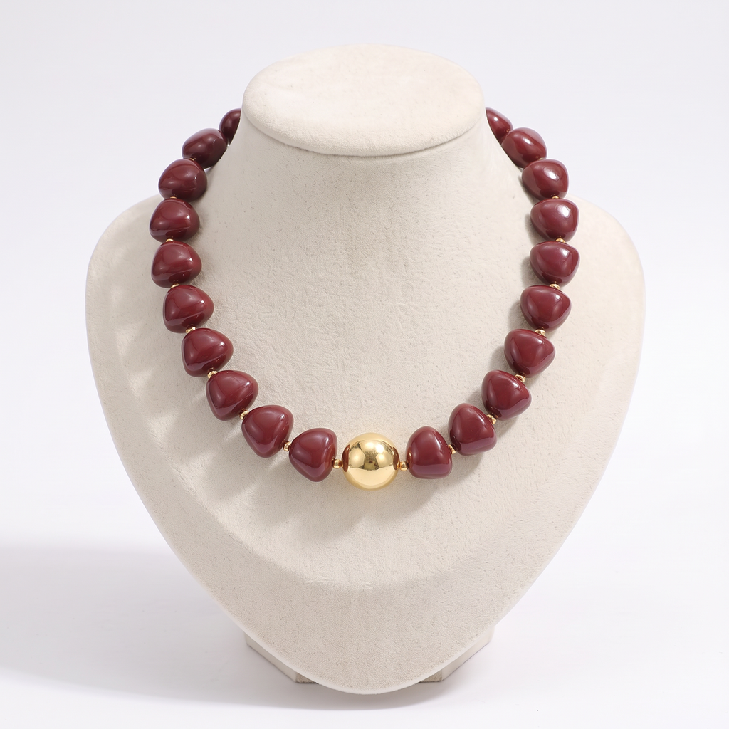 Collier de perles doré à sphères, vue de face, bordeaux