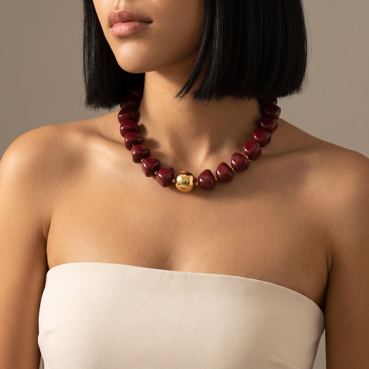 Collier de perles doré à sphères, porté mi-corps, bordeaux