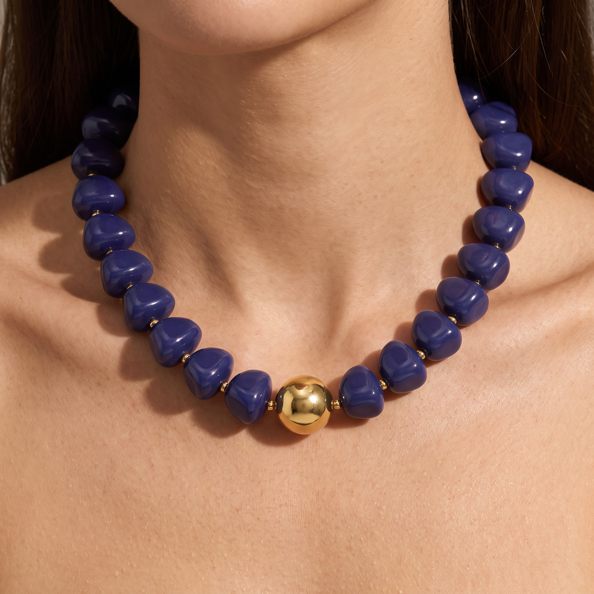 Collier de perles doré à sphères, porté, bleu foncé