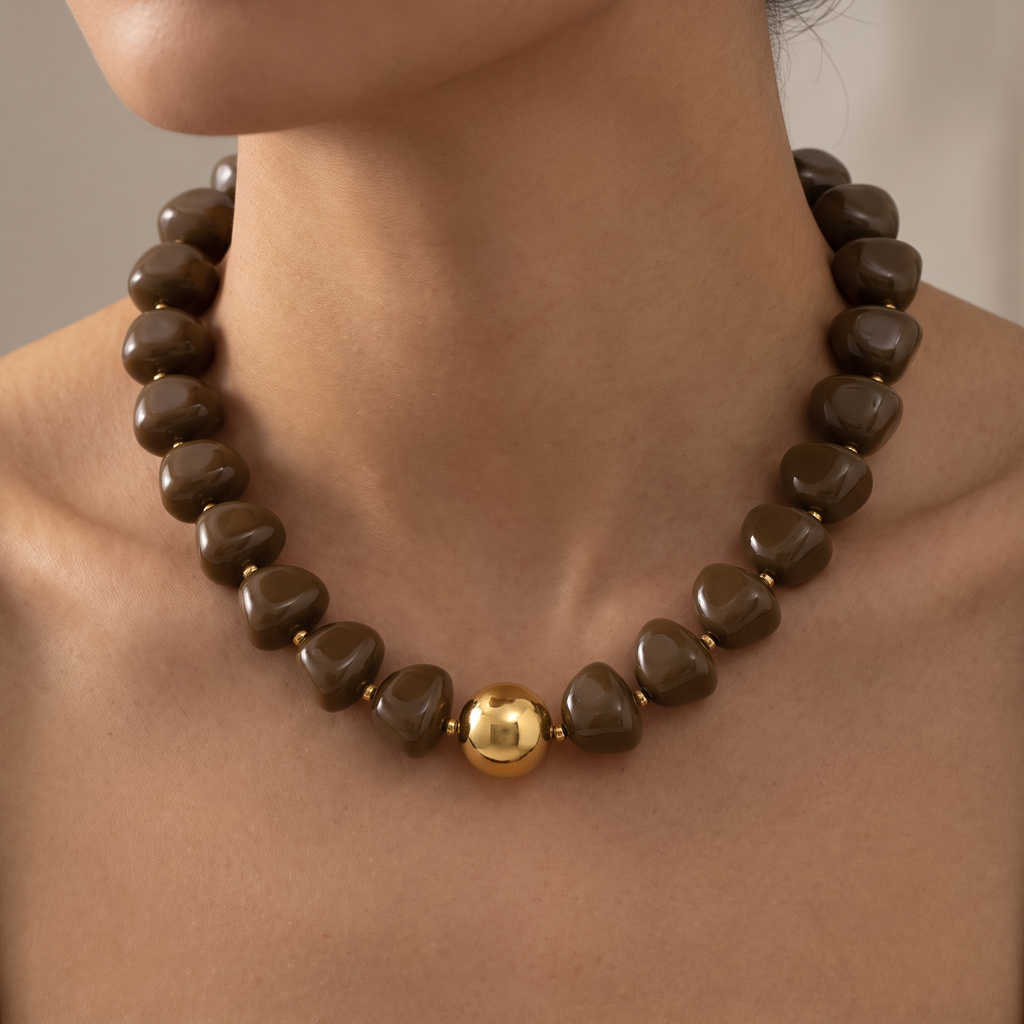 Collier de perles doré à sphères, porté, brun foncé