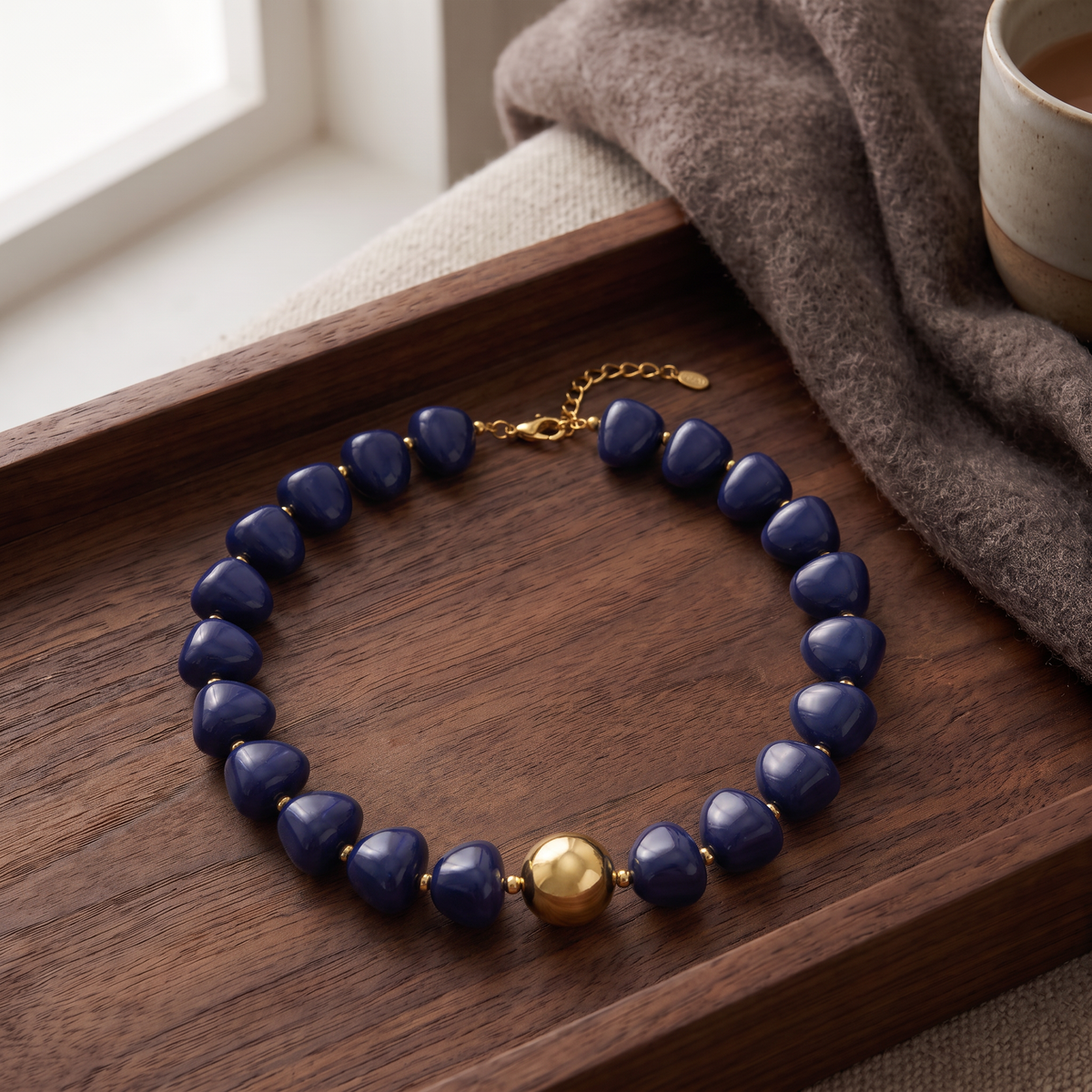 Collier de perles doré à sphères, porté en tenue, bleu foncé
