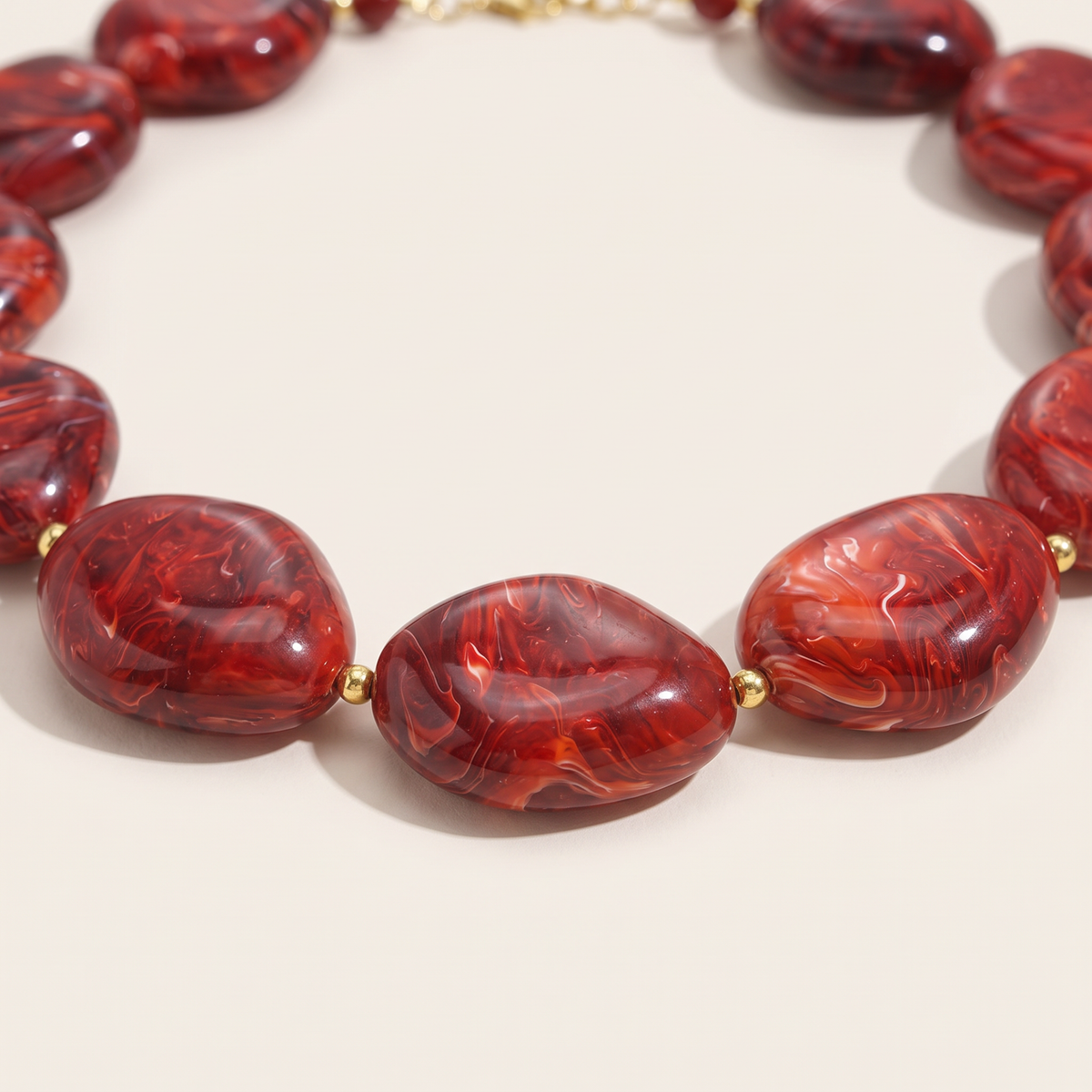 Collier de perles effet marbré oversize, détail du motif, bordeaux
