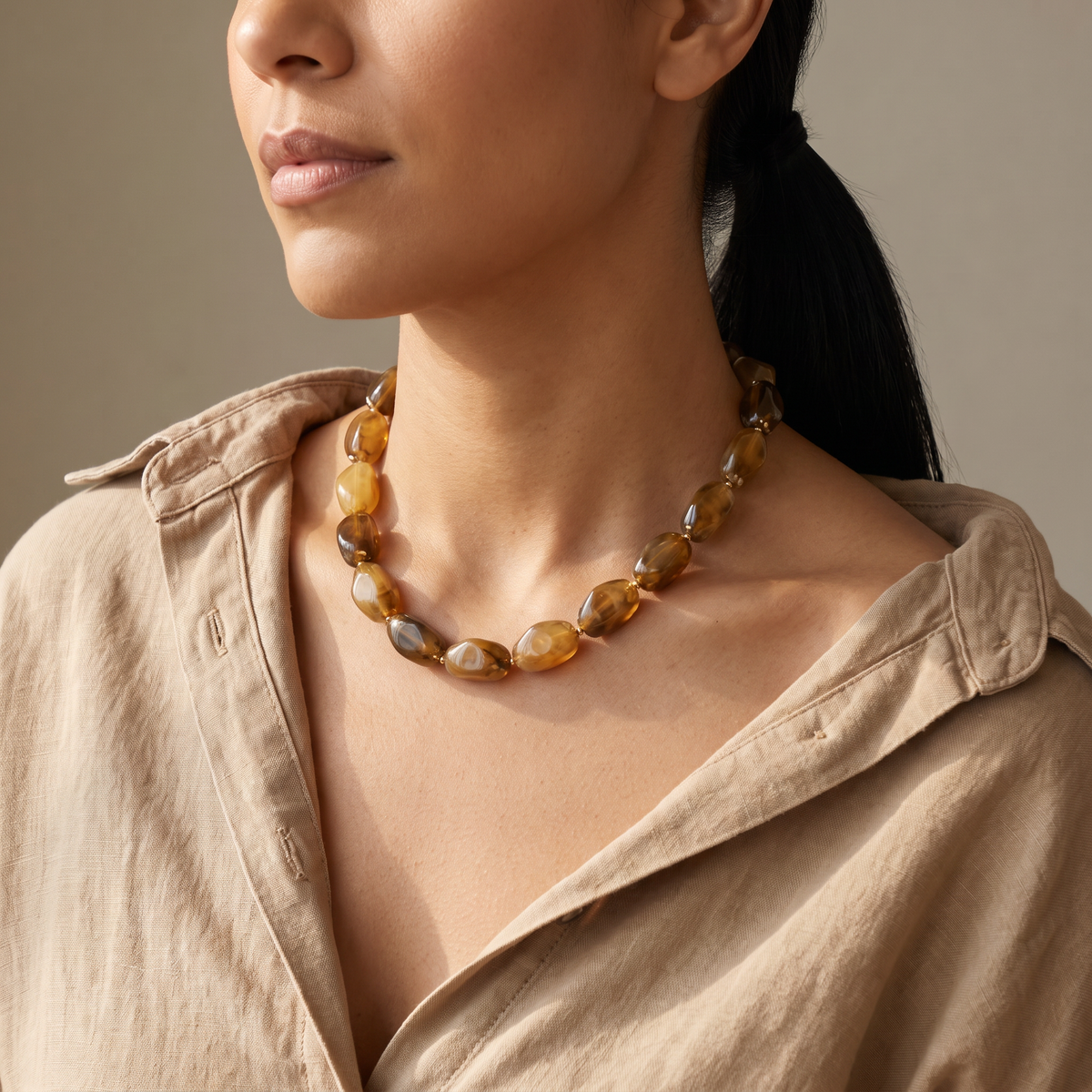 Collier de perles à forme organique, porté mi-corps, marron
