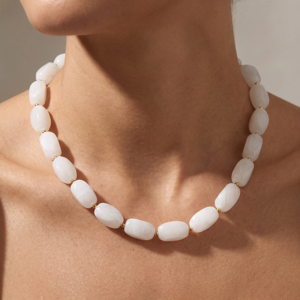 Collier de perles à forme organique, porté, blanc cassé