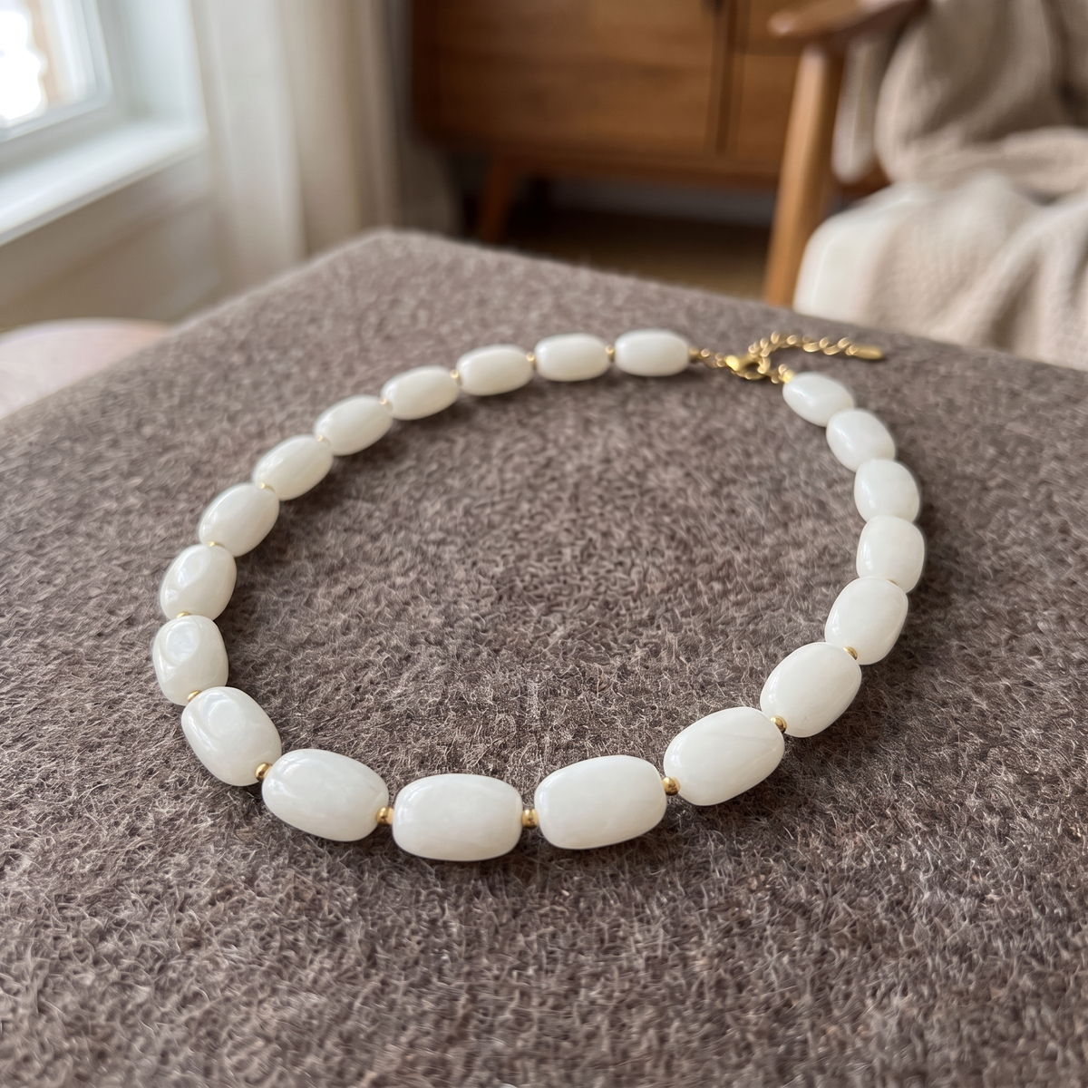 Collier de perles à forme organique, porté en tenue, blanc cassé