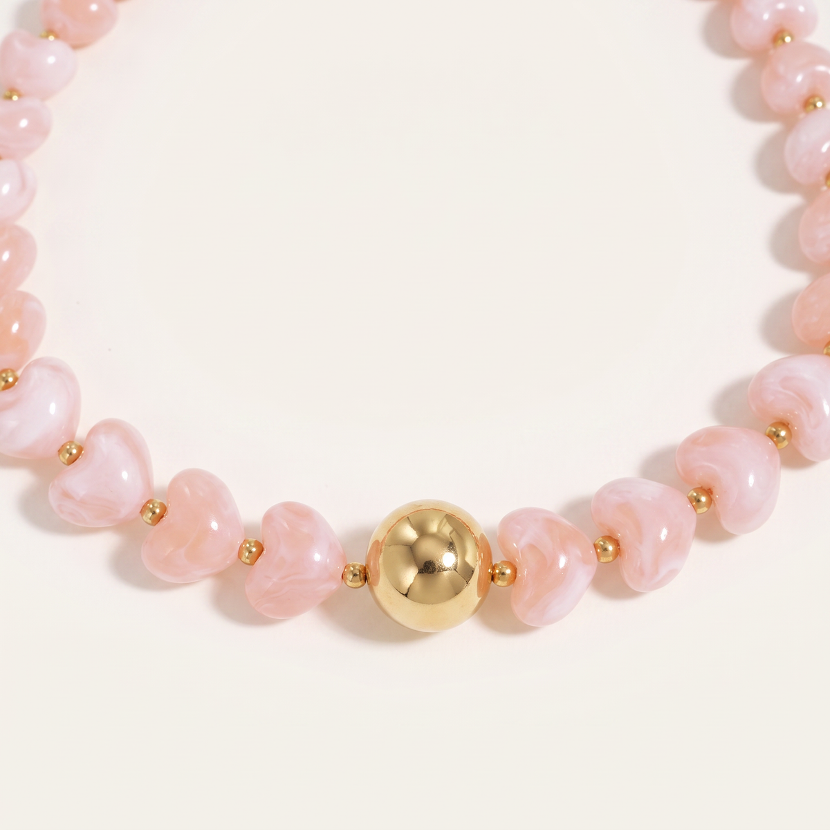 Collier cœur doré en perles 42 cm, détail du motif, rose clair