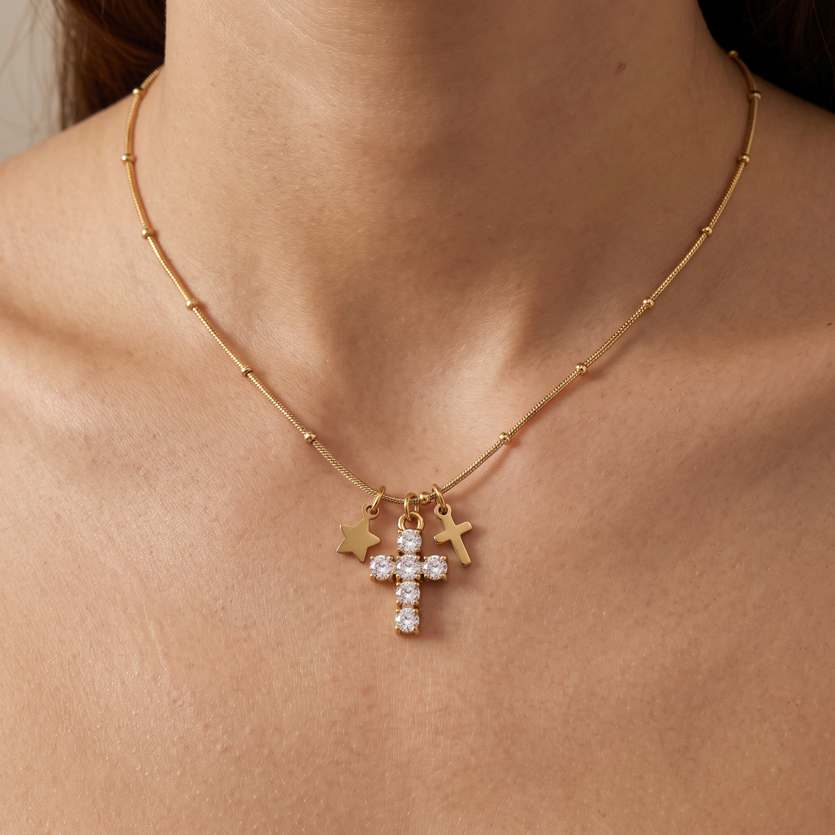 Collier croix et étoile à strass, porté, doré