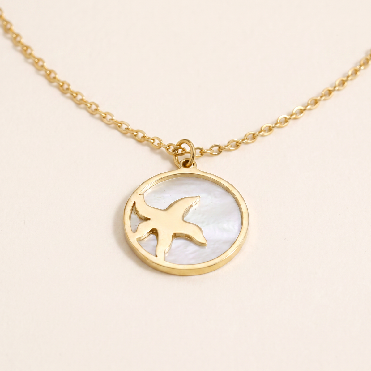 Collier étoile de mer et coquillage à médaillon, détail du motif, doré