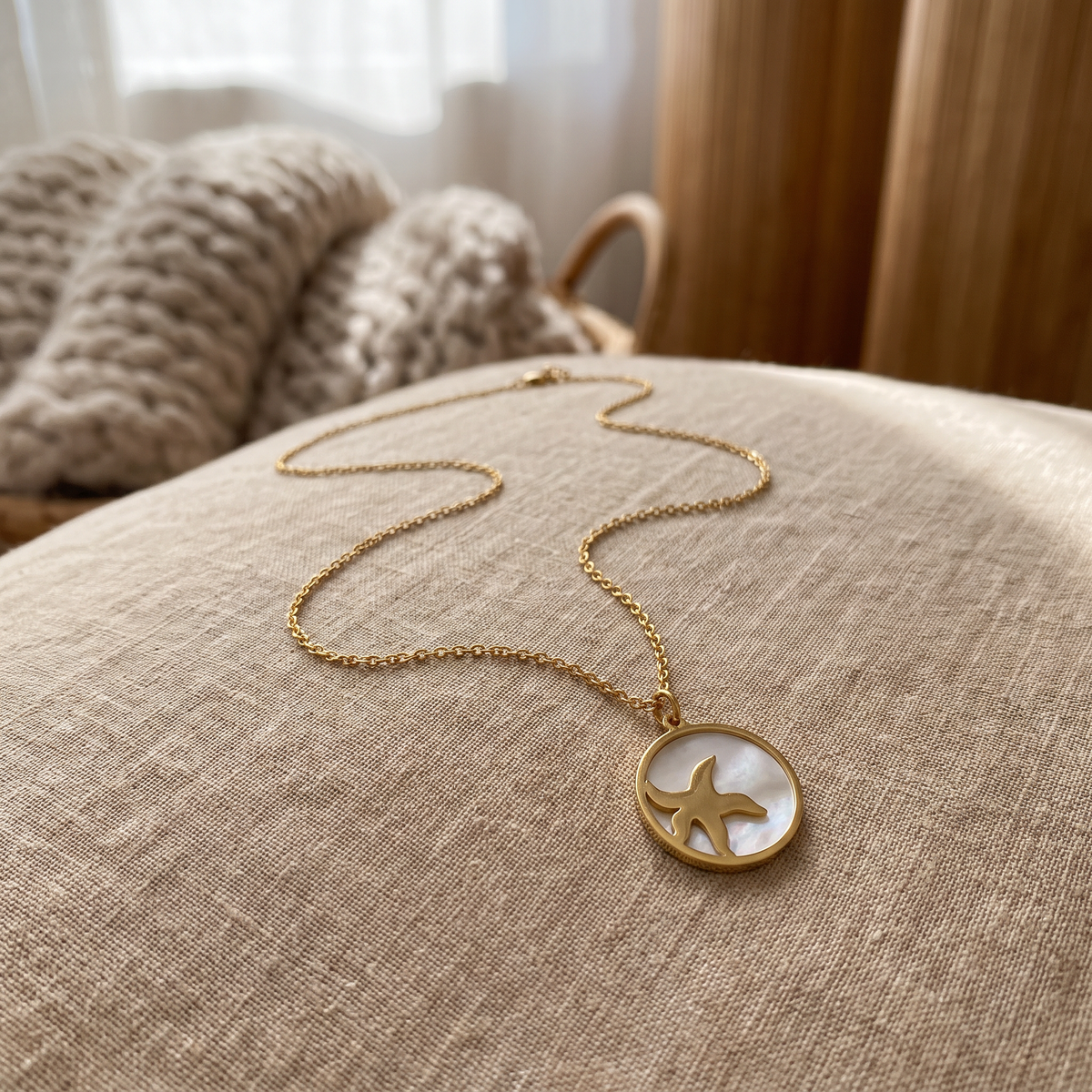 Collier étoile de mer et coquillage à médaillon, porté en tenue, doré