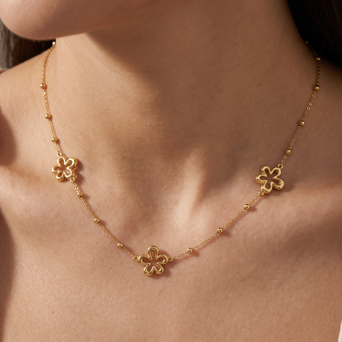 Collier charms fleur à motif ajouré, porté, doré
