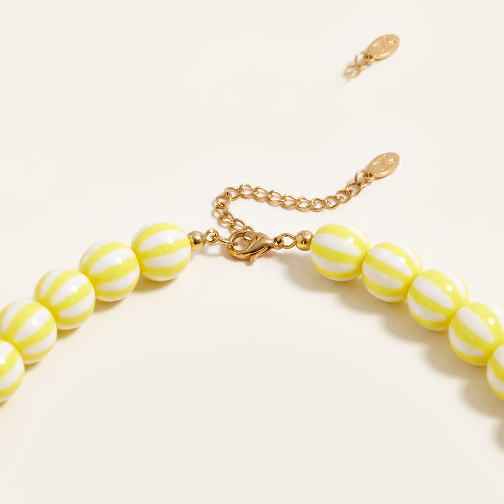 Collier de perles rayé en couleurs, détail du motif, jaune