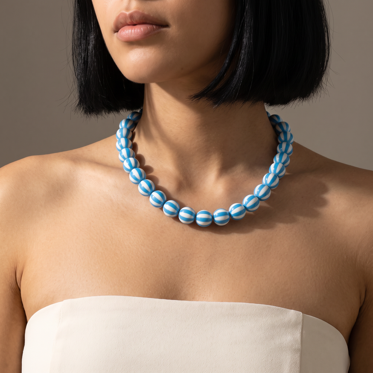 Collier de perles rayé en couleurs, porté mi-corps, bleu