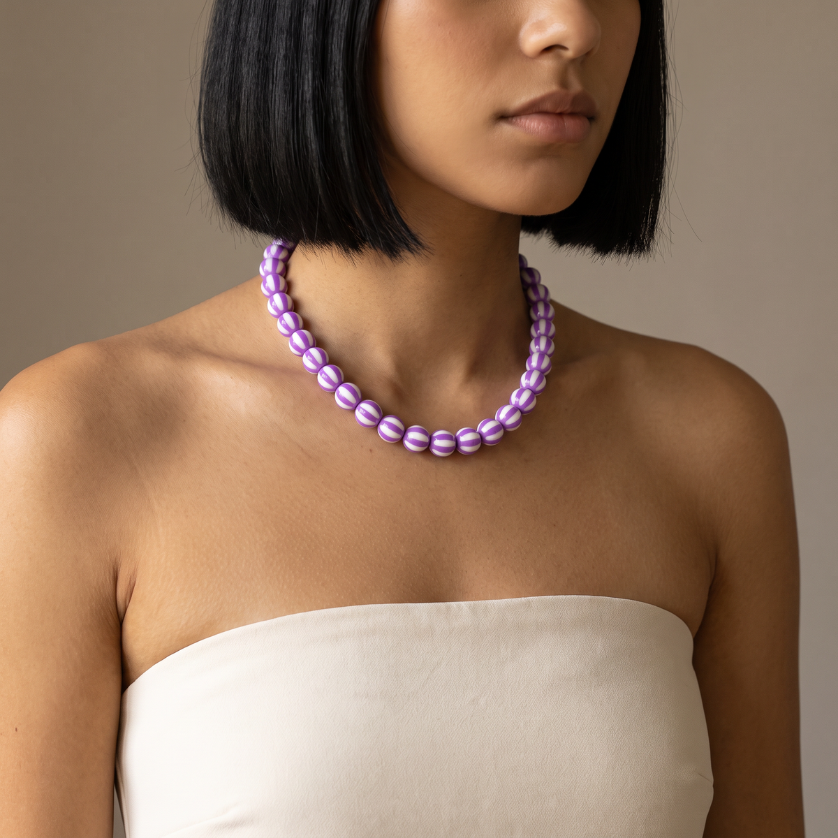 Collier de perles rayé en couleurs, porté mi-corps, violet