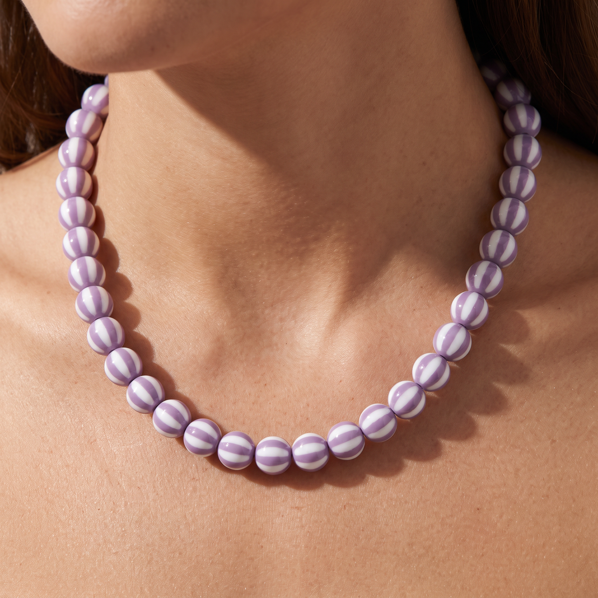 Collier de perles rayé en couleurs, porté, violet clair