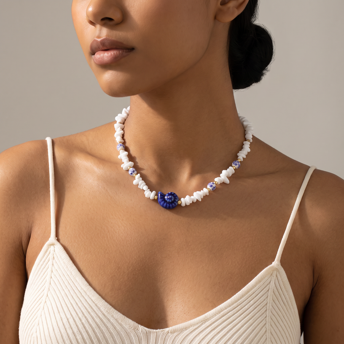 Collier coquillage esprit azulejos bleu en perles, porté mi-corps