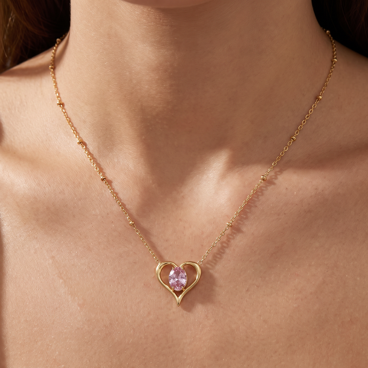 Collier cœur doré à motif ajouré à strass, porté, rose