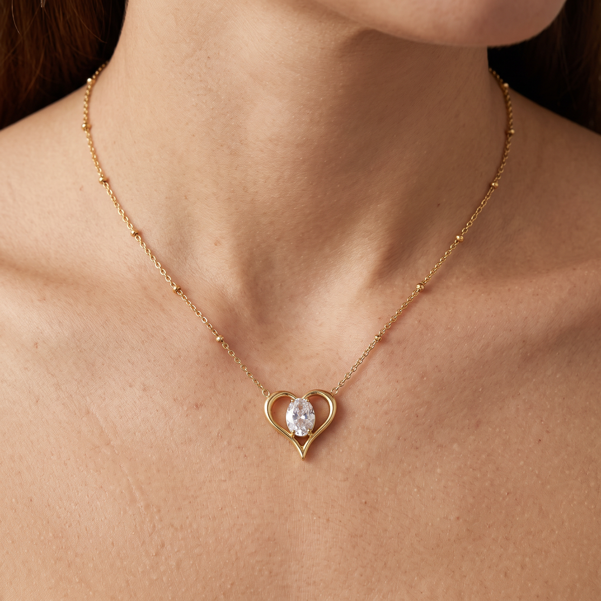 Collier cœur doré à motif ajouré à strass, porté