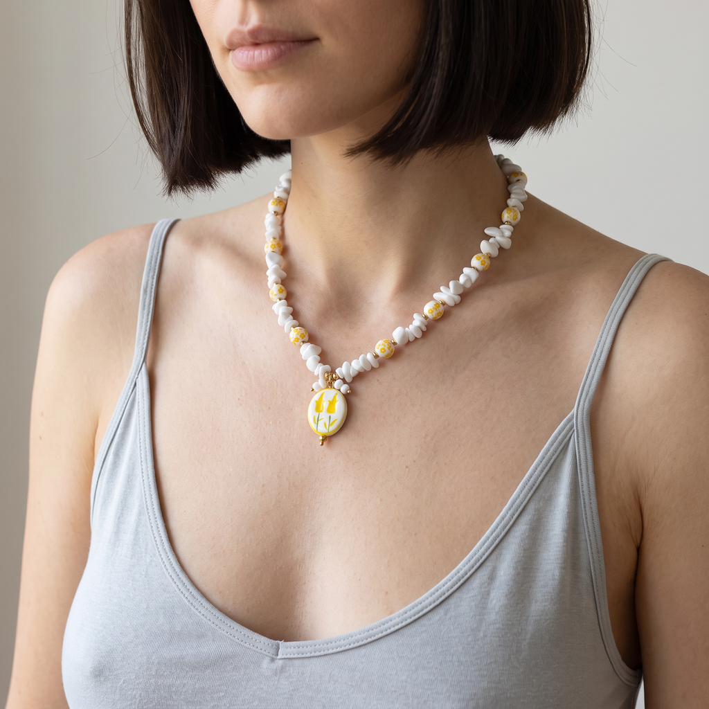 Collier fleur jaune en perles, porté mi-corps