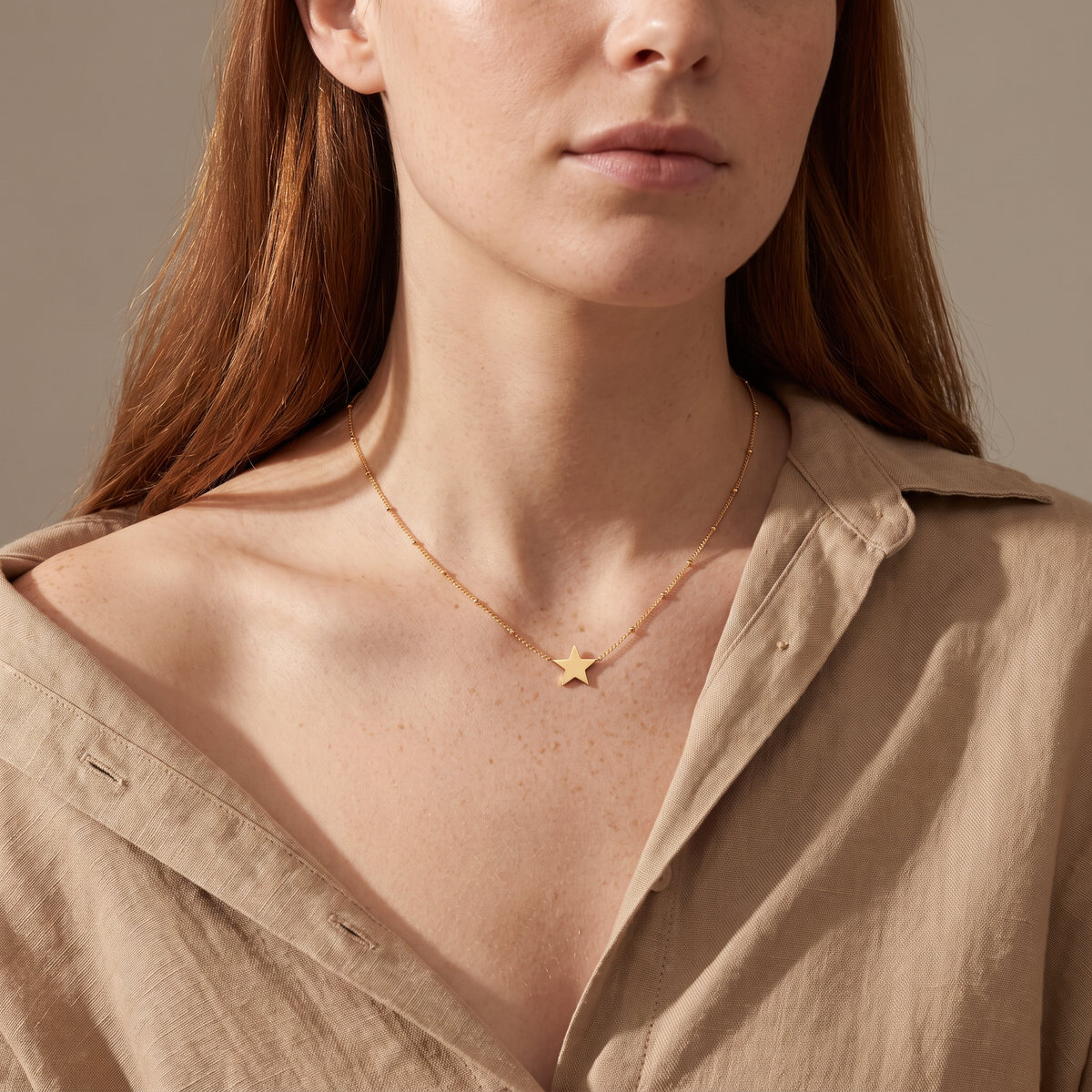 Collier étoile, porté mi-corps, doré