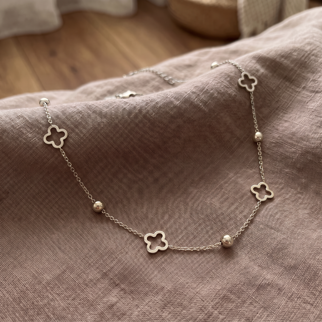 Collier ras de cou trèfle à motif ajouré, porté en tenue, argenté